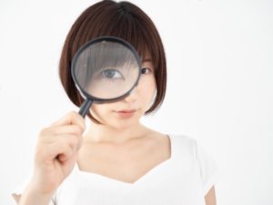 虫眼鏡を覗いている女性の画像